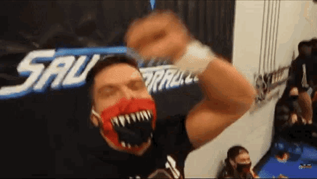 a man wearing a red mask with sharp teeth is standing in front of a sign that says sal