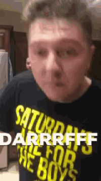 a man wearing a black shirt that says saturday night for the boys