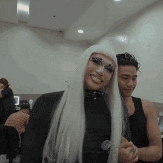 a woman in a white wig is smiling next to a man