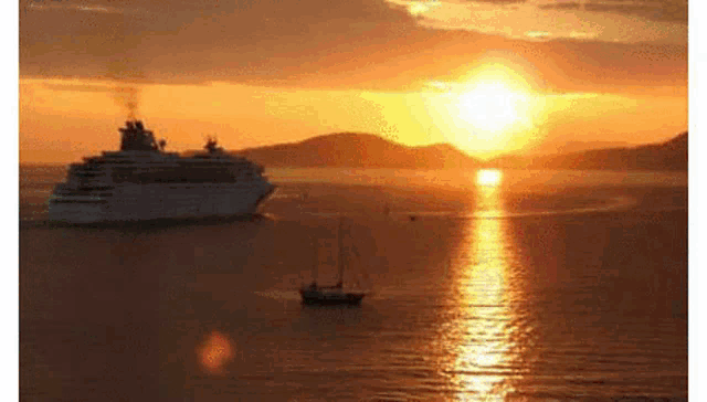 a cruise ship is floating in the ocean at sunset .