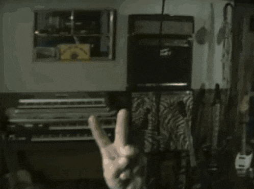 a person making a peace sign in front of a sign that says " headstockburn "