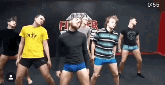a group of young men are dancing in front of a wall that says fighter