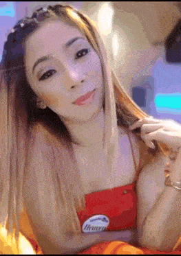 a woman wearing a red top with a heaven badge on her chest