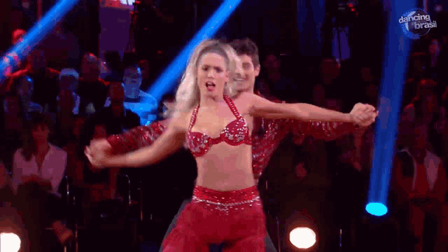 a man and a woman are dancing in front of a dancing brasil sign