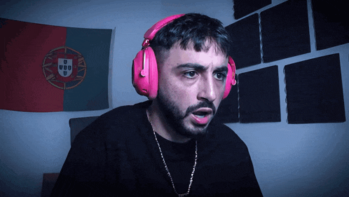 a man wearing pink headphones has the letter u on his head