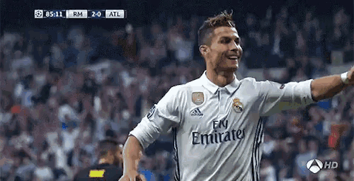 a soccer player wearing an emirates jersey is celebrating