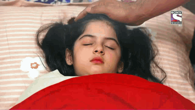 a little girl laying in bed with her eyes closed and a sony logo on the corner