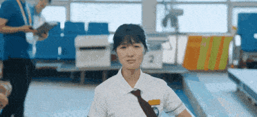 a girl in a white shirt and tie with the number 2 on her shirt