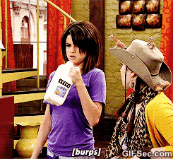 a woman in a purple shirt is holding a bottle that says ' xerox ' on it