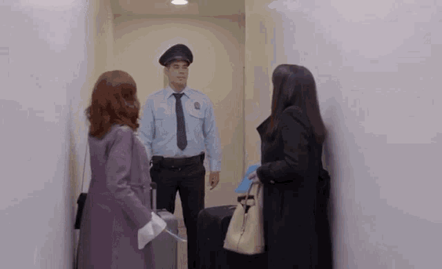 a woman in a purple coat is talking to a man in a police uniform