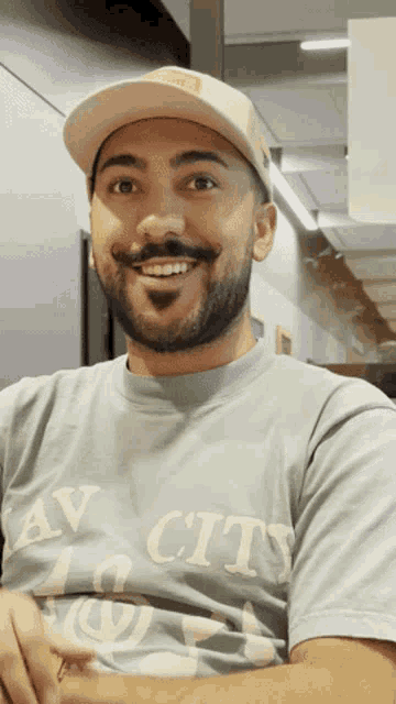 a man wearing a hat and a t-shirt that says av city