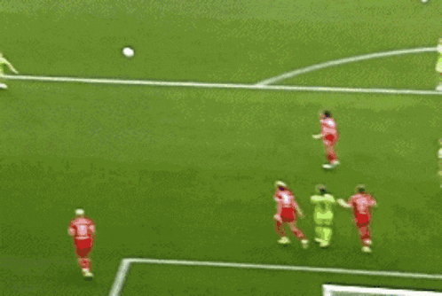 a soccer game is being played on a field with players in red and green jerseys