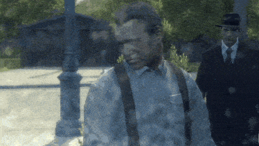 a man in a suit and suspenders is walking down a street