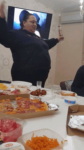 a woman is standing in front of a table full of food including a container that says ' cottage cheese ' on it