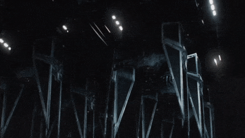 a group of robots are flying through the air in a dark room