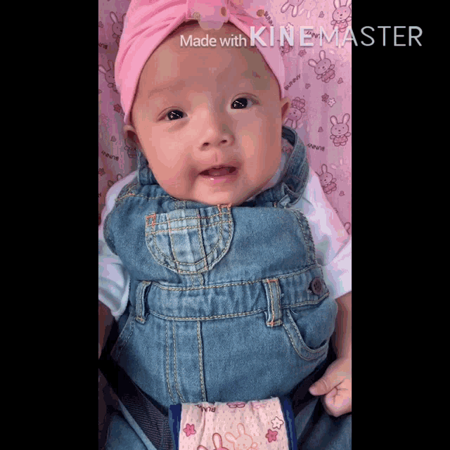 a baby wearing overalls and a pink headband is being made with kinemaster