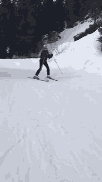 a person is skiing down a snow covered hill .