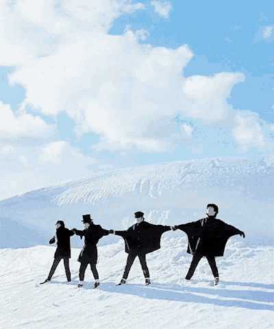 a group of people are standing in the snow with their arms outstretched