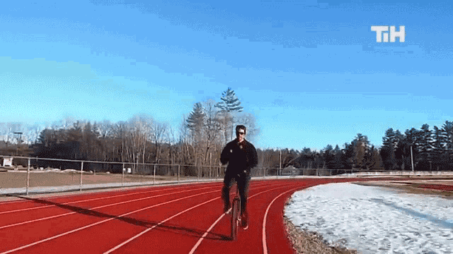 a man is riding a bike on a track with the letters tih on the bottom