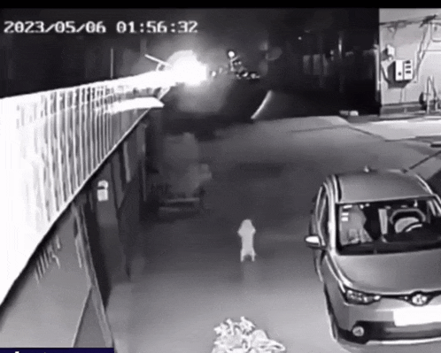a car is parked in front of a building with the time of 01:56:32 on it