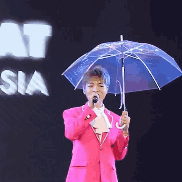 a man in a pink suit is holding a clear umbrella