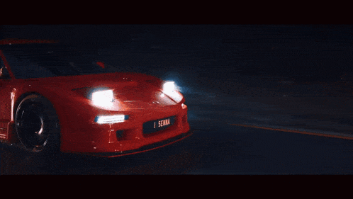 a red senna car is driving down the road