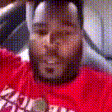 a man with a beard is wearing a red t-shirt that says ' miami ' on it .
