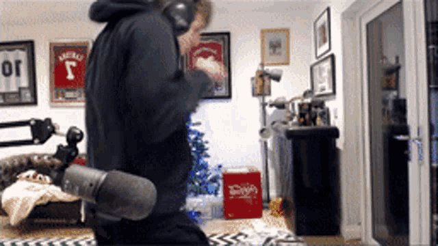a man wearing headphones stands in front of a microphone in a room with a coca cola box