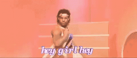 a man is standing on a stage with the words `` hey girl hey '' written above him .