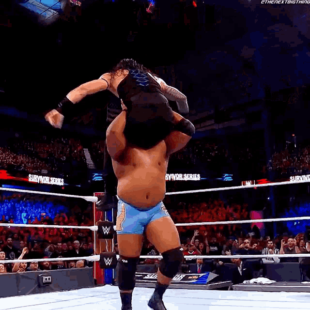 a wrestler is being lifted in the air by another wrestler in a wrestling ring