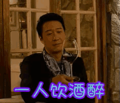 a man holding a glass of wine in front of a window with chinese writing behind him