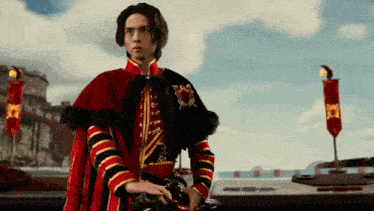 a man in a red and gold costume with a black cape