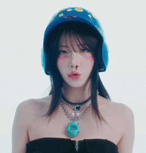 a woman wearing a blue helmet with smiley faces on it looks at the camera
