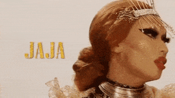 a drag queen with red hair and a crown on her head is wearing a necklace .