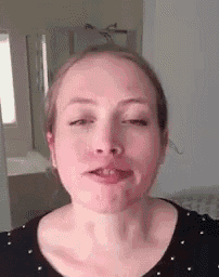 a close up of a woman 's face with her eyes closed and her mouth open .