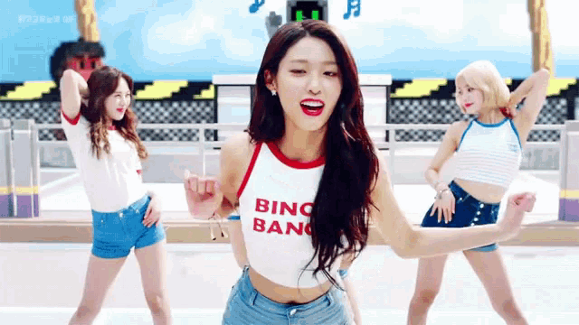 a woman in a white crop top is dancing with other women .