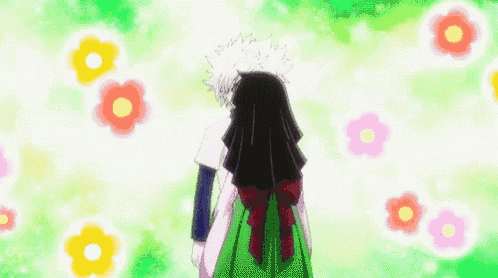 a girl in a green dress is hugging a boy