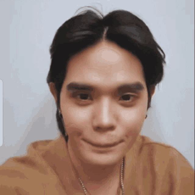 a close up of a man 's face with a necklace around his neck making a funny face .