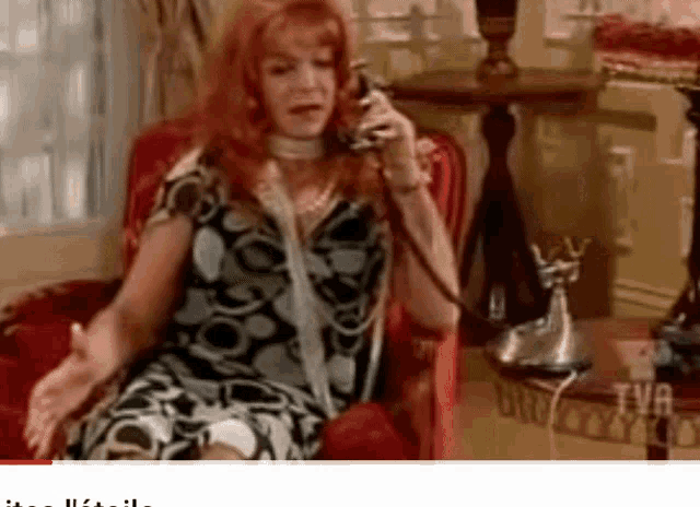 a woman sits in a chair talking on a phone