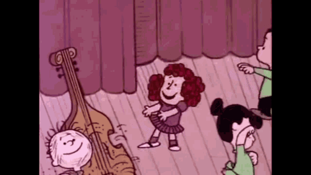a group of peanuts characters are dancing on a stage while a boy plays a double bass .