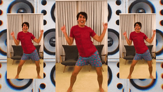 a man in a red shirt and blue shorts is dancing in a room
