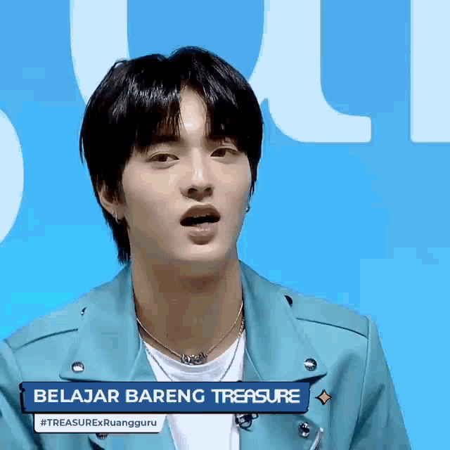 a young man wearing a blue jacket and a necklace with the words belajar bareng treasure on it