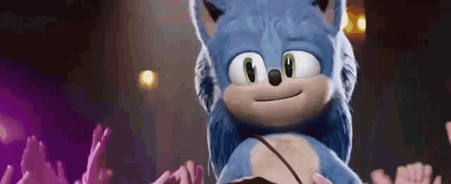 a close up of a stuffed animal called sonic the hedgehog in front of a crowd of people .