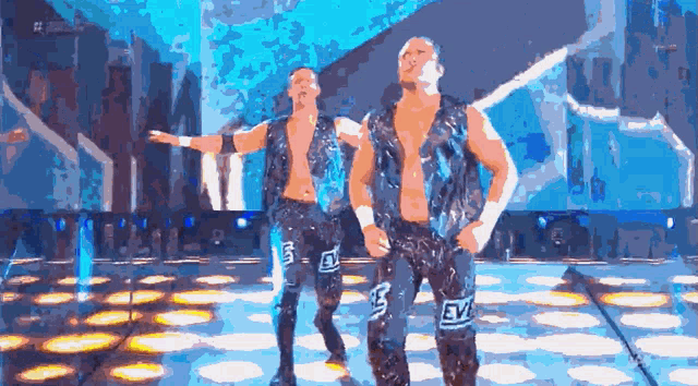 two men are dancing on a stage and one of their pants says evl on it
