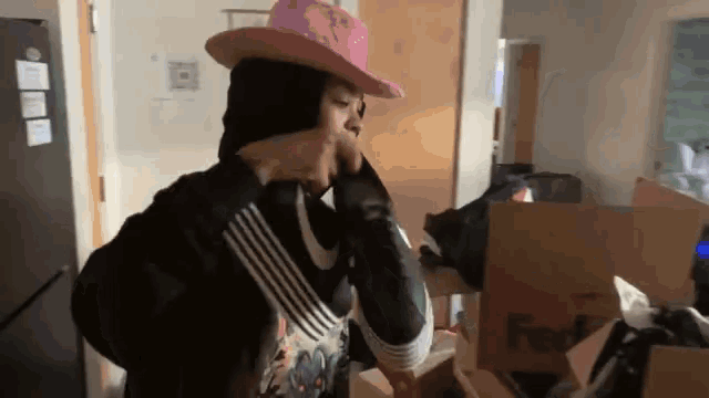 a person wearing a pink hat and a fedex box