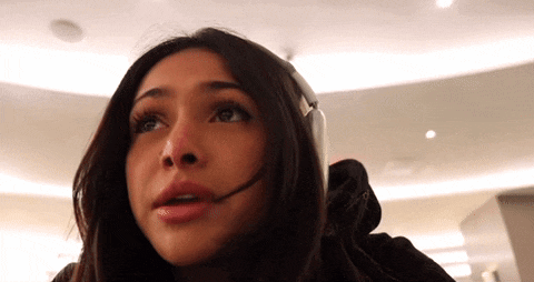 a woman wearing headphones and a headset is talking on a cell phone .