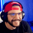 a man with a beard wearing headphones and a red headband .