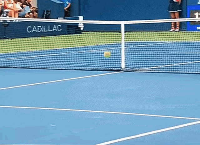 a tennis ball is going through a net on a tennis court
