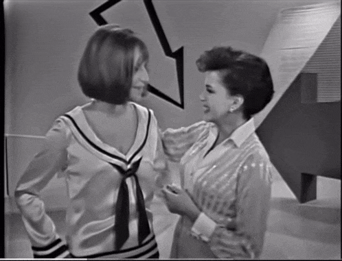 two women are standing next to each other and talking