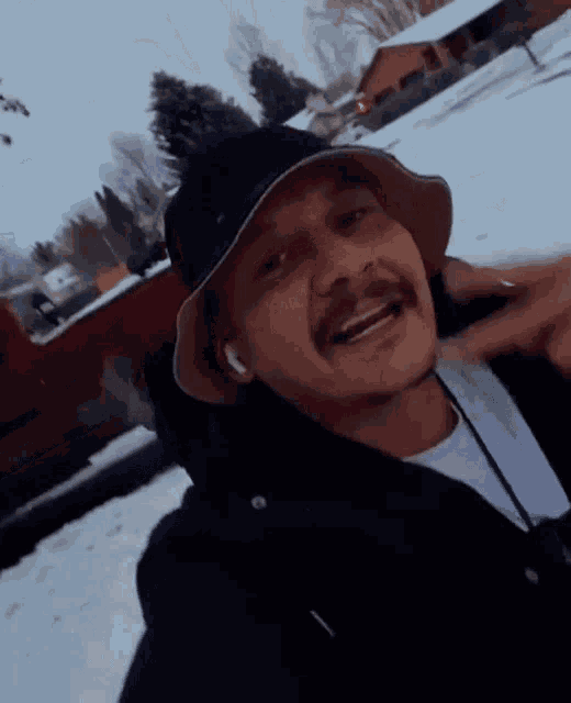 a man wearing a hat and headphones is smiling